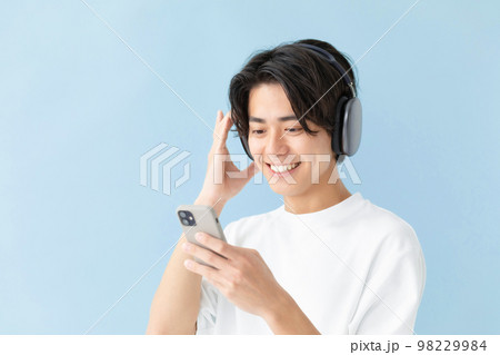 男性　ヘッドフォン　音楽　ブルーバック 98229984