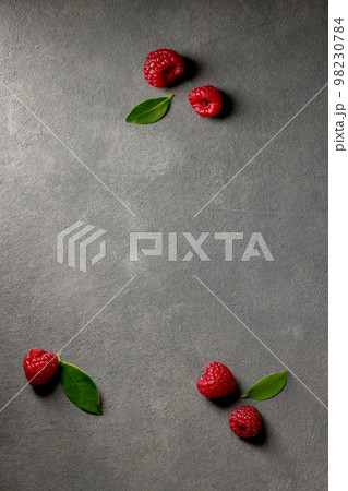 raspberries and green leaves 98230784