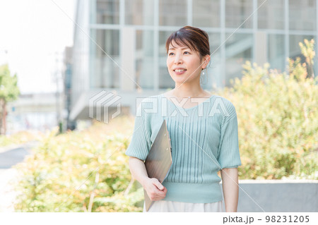ビルの前で立つビジネスウーマン・OL・女性（30代・40代・アジア人,日本人,中国人） 98231205