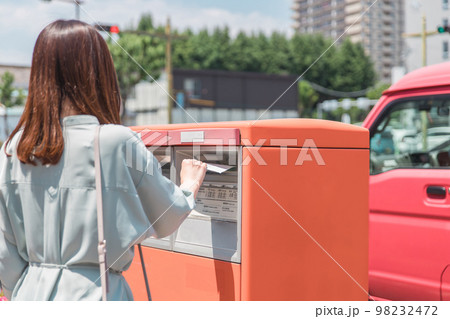 郵便ポストに手紙を投函する女性・ビジネスウーマン 98232472
