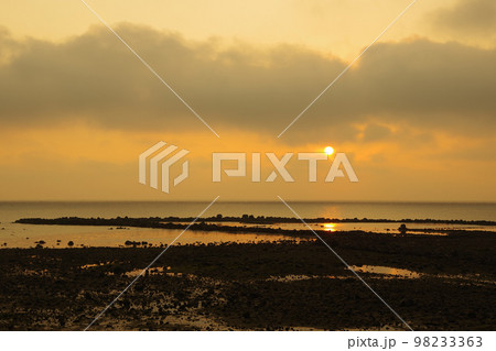 雲で見え隠れする朝日と有明海に差し込む光 98233363