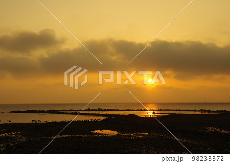 雲で見え隠れする朝日と有明海に差し込む光 98233372