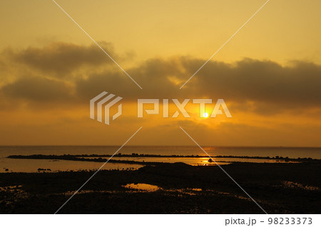 雲で見え隠れする朝日と有明海に差し込む光 98233373