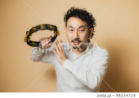 タンバリンを持つ髭の男性 98234729