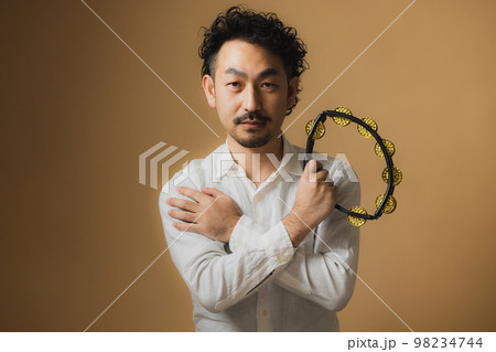 タンバリンを持つ髭の男性 98234744