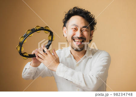 タンバリンを持つ髭の男性 98234748