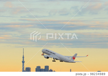 朝日を浴びて離陸する旅客機 離陸上昇するジェット機 東京スカイツリーを背景に離陸するJAL機 朝日を浴びて離陸する旅客機 離陸上昇するジェット機 東京スカイツリーを背景に離陸するJAL機 98234989
