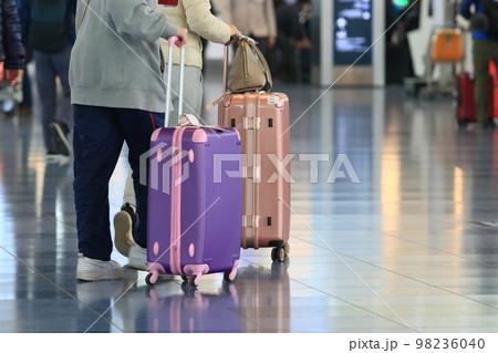 スーツケースを引く旅行客　羽田空港　出発ロビー　旅行客　 98236040