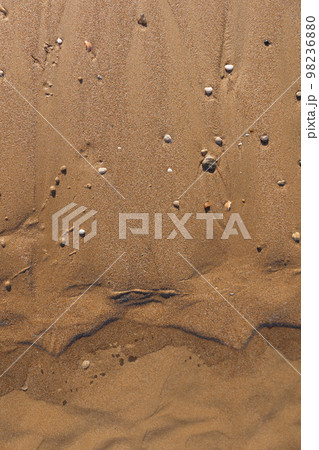 Ripples on wet sand with small stones, sandy texture, calm and natural background with copy space for text 98236880