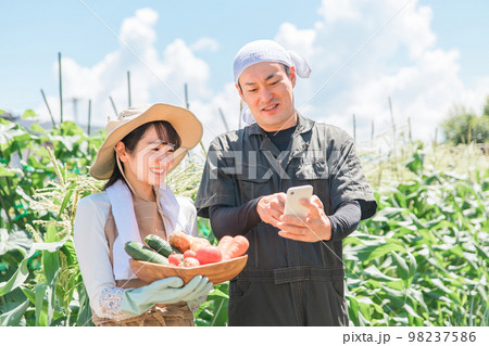 スマートフォン・スマホ・アプリで農業の管理をするアジア人の男女(男性・女性) スマートフォン・スマホ・アプリで農業の管理をするアジア人の男女(男性・女性) 98237586