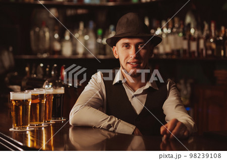 happy bearded bartender at bar counter with glasses of beer happy bearded bartender at bar counter with glasses of beer 98239108