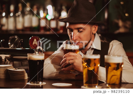 bartender at bar counter tasting various varieties of craft beer 98239110