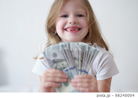 Portrait of happy smiling little girl with fan of dollars 98240004