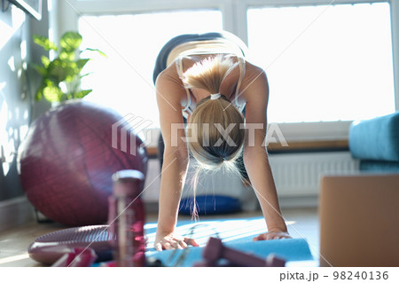 Fitness woman exercising at home and doing full plank 98240136