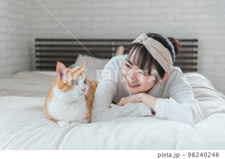 家のベッドルームでペットの猫と遊ぶアジア人女性 家のベッドルームでペットの猫と遊ぶアジア人女性 98240246