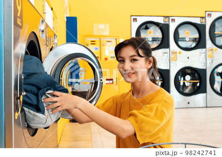 Asian people using qualified laundry machine in the public room. Asian people using qualified laundry machine in the public room. 98242741