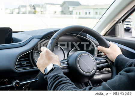 車を運転する男性の手元 98245639