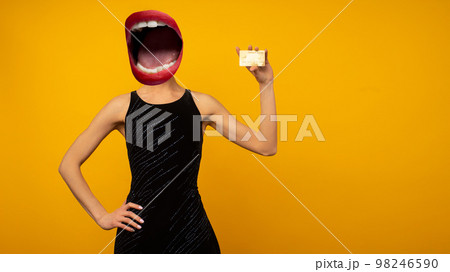 Contemporary art collage. Composition with young woman headed of female mouth in black dress showing credit card on yellow background Contemporary art collage. Composition with young woman headed of female mouth in black dress showing credit card on yellow background 98246590