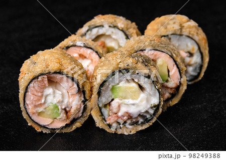 baked sushi rolls with salmon without rice on black baked sushi rolls with salmon without rice on black 98249388