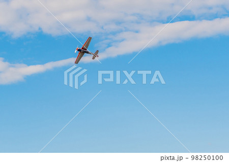 Light aircraft flying in blue sky at Air Show 98250100