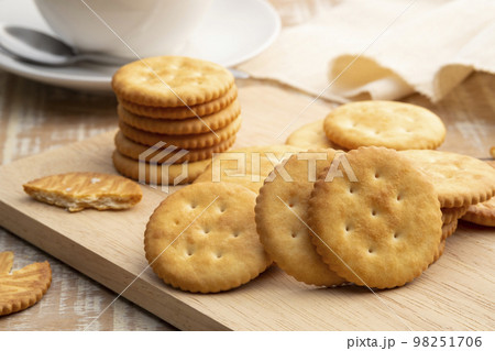 Heap of Dry thin crispy crackers on cutting board on wood table 98251706