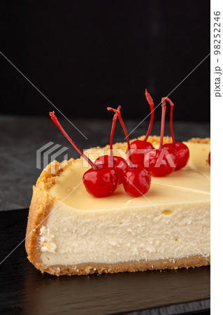classic cheesecake decorated with cherries on a dark background classic cheesecake decorated with cherries on a dark background 98252246