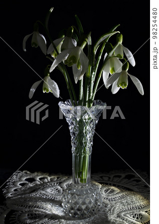 Snowdrops decorated in a glass vase. 98254480