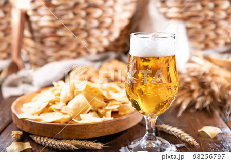 Glass of light craft beer on a wooden table. Beer is poured into a glass with foam and bubbles. for 98256797