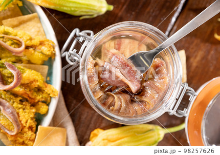 Anchovies in a jar, on a wooden rustic background. Traditional italian food of the south of italy Anchovies in a jar, on a wooden rustic background. Traditional italian food of the south of italy 98257626