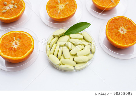 Vitamin C pills with  fresh orange citrus fruit isolated on white background. 98258095