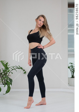 Full length portrait of a beautiful caucasian woman in black sportswear.  98258670