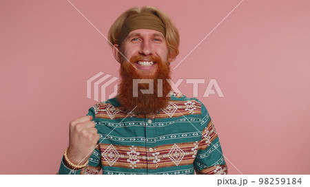 Hippie man in pattern shirt shouting raising fists in gesture I did it, celebrating success winning 98259184