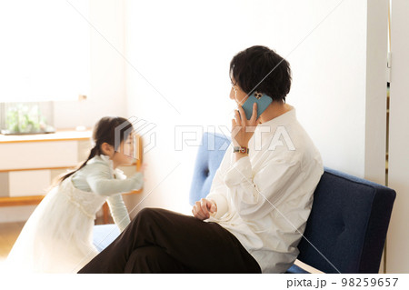部屋で電話をする男性 部屋で電話をする男性 98259657