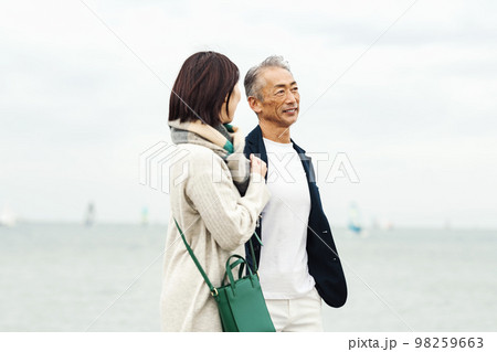 女性と海辺を歩く白髪のミドル男性 女性と海辺を歩く白髪のミドル男性 98259663