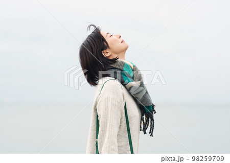 冬の海に出かける女性 98259709