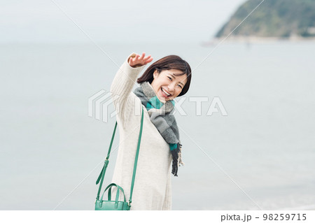 冬の海に出かける女性 98259715