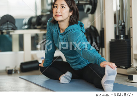 スポーツジムでストレッチをする女性 スポーツジムでストレッチをする女性 98259777