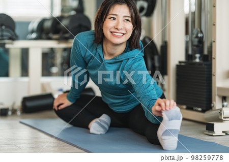 スポーツジムでストレッチをする女性 スポーツジムでストレッチをする女性 98259778