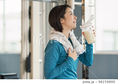 スポーツジムで筋トレ後にプロテインを飲む女性 スポーツジムで筋トレ後にプロテインを飲む女性 98259800