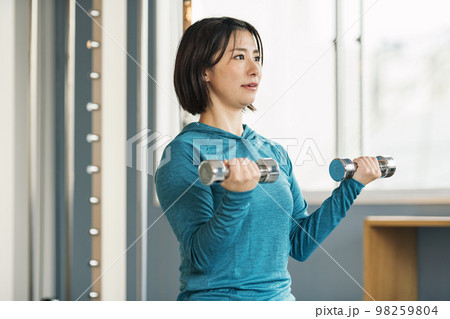 スポーツジムで鉄アレイを使って筋トレをする女性 スポーツジムで鉄アレイを使って筋トレをする女性 98259804
