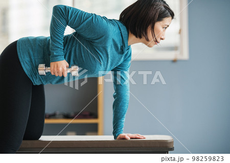 スポーツジムで筋トレをする若い女性 98259823