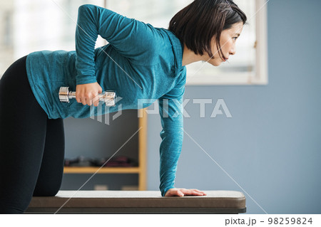 スポーツジムで筋トレをする若い女性 スポーツジムで筋トレをする若い女性 98259824