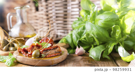 Capers and Dried tomatoes with herbs in olive oil.Large capers. Traditional appetizers in Italy with Capers and Dried tomatoes with herbs in olive oil.Large capers. Traditional appetizers in Italy with 98259931