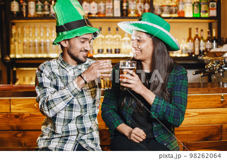Indian friends celebrate St. Patrick's Day in a pub 98262064