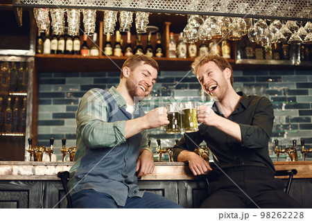 Men at bar behind bar with beer Men at bar behind bar with beer 98262228