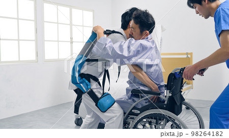 パワーアシストスーツをつけて患者を抱える看護師　移乗介助機器 98264182