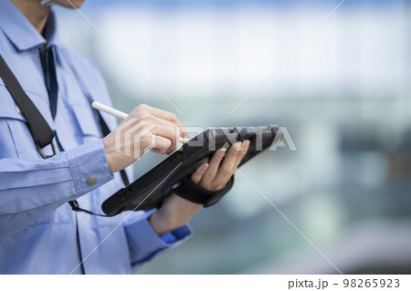 タブレットにペンで入力する作業服姿の男性の手元　撮影協力「LINK FOREST」 98265923