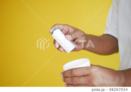 young man putting artificial sweetener in tea with copy space  98267034