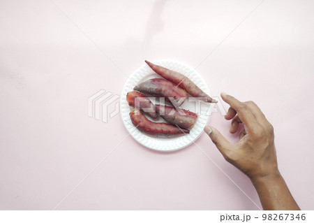 top view of hand pick raw sweet potato in a bowl  98267346
