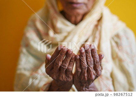 Close up of senior women hand praying at ramadan Close up of senior women hand praying at ramadan 98267512